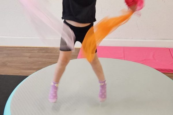 Young dancer jumping with scarves on the air track at Got2Dance